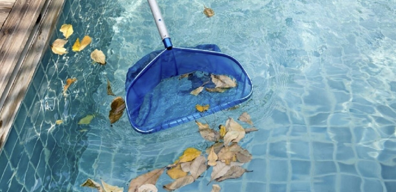 Pool technician using skimmer to remove leaves and debris in Prescott, AZ